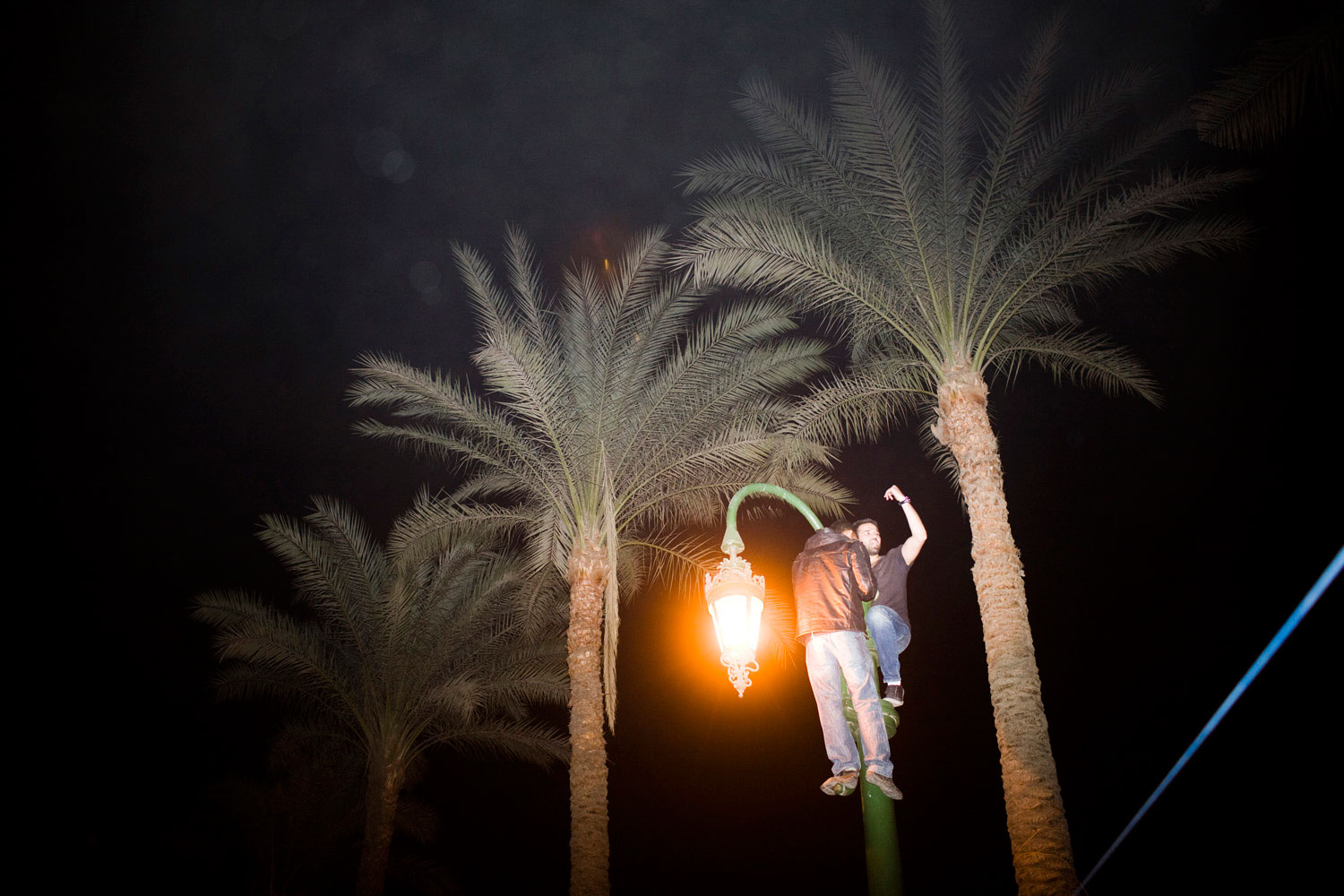 A protestor celebrates on a light pole after the news of Mubarak's resignation spread through the streets of Cairo.