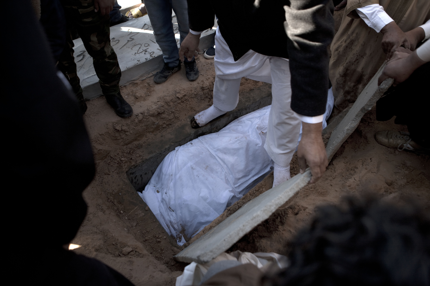 Tripoli residents bury some bombing victims at the martyrs cemetery in Tripoli