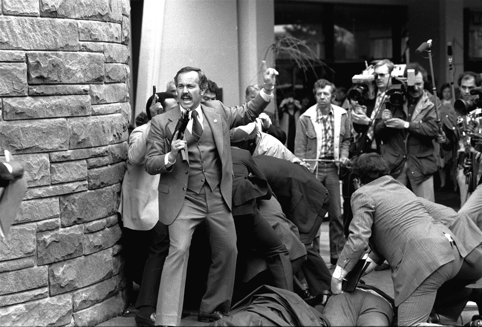Agents and aides continued to wrestle with Hinckley and attend to Brady and the other victims as bystanders and press looked on.