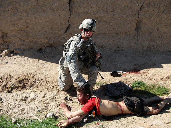 This image, published by Rolling Stone, shows the body of Gul Mudin, the son of a farmer, who was killed on Jan. 15, 2010. Pfc. Andrew Holmes, a member of the  kill team  is posing next to him.
