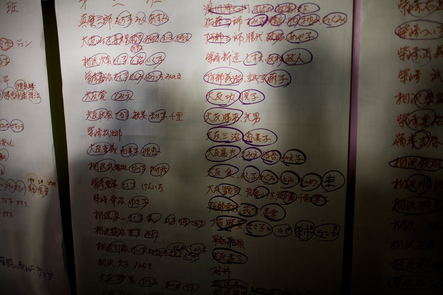 A list of survivors hangs in a school gymnasium in Natori on March 13, 2011
