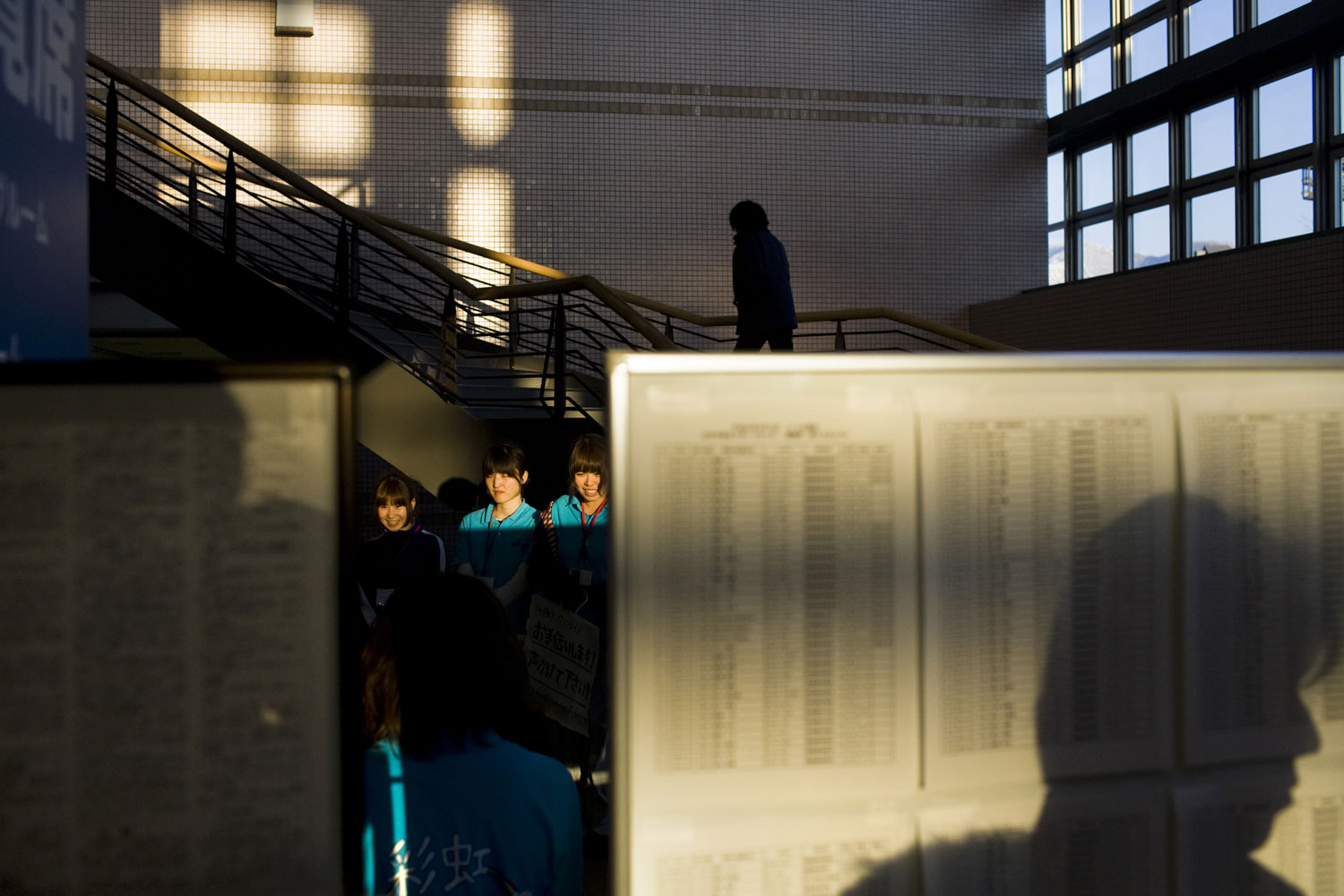 People scan the missing persons list at a shelter in Yamagata March 18, 2011.
