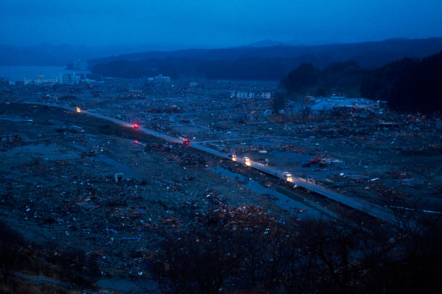 Japanese vehicles pass through the ruins of the leveled city of Minamisanriku, in northeastern Japan, March 15, 2011.