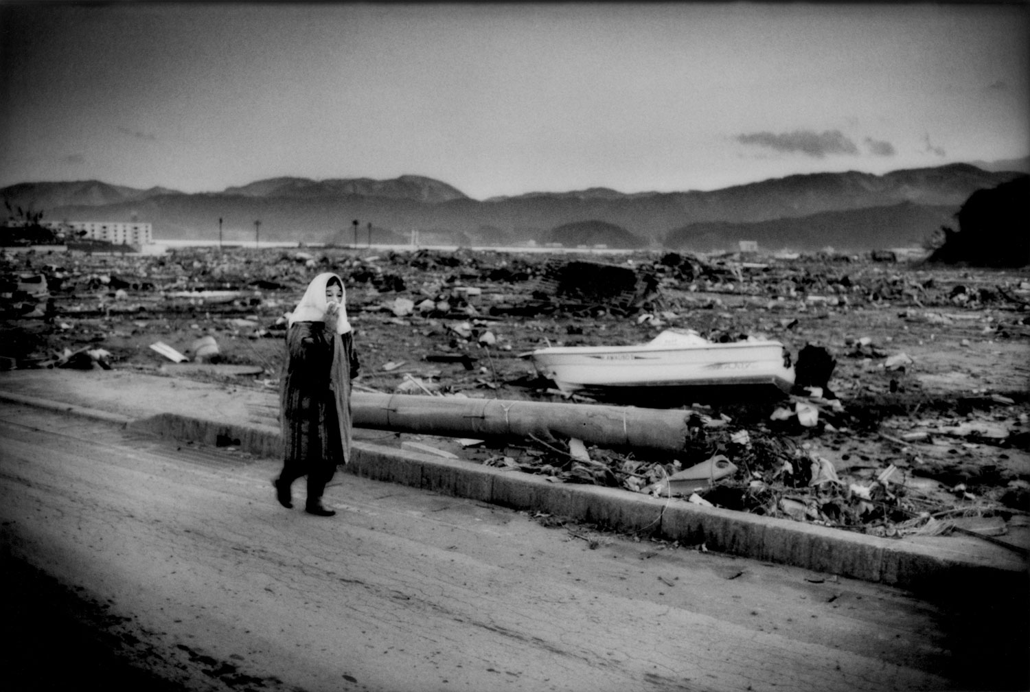 An elderly woman shuffles through the destroyed city of Rikuzen-Takata, Iwate Prefecture, Japan. In Rikuzen-Takata, 10,547 residents, nearly half the population of roughly 26,000 people, are living in evacuation shelters.  Japan Self Defence Forces say they have found 300 to 400 bodies there. About 5,000 of the city's houses were submerged by the quake-triggered tsunami.