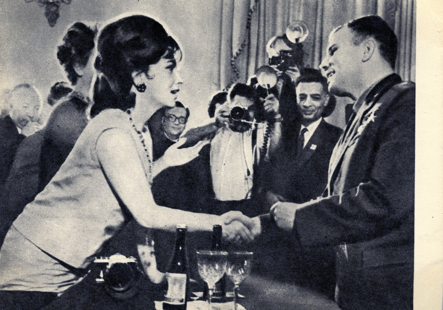 Gagarin is congratulated by Italian movie star Gina Lollobrigida. The caption wonders:  A man who has been in space! What is he like? Hundreds of thousands of people rush to shake his hand, offer him good wishes.