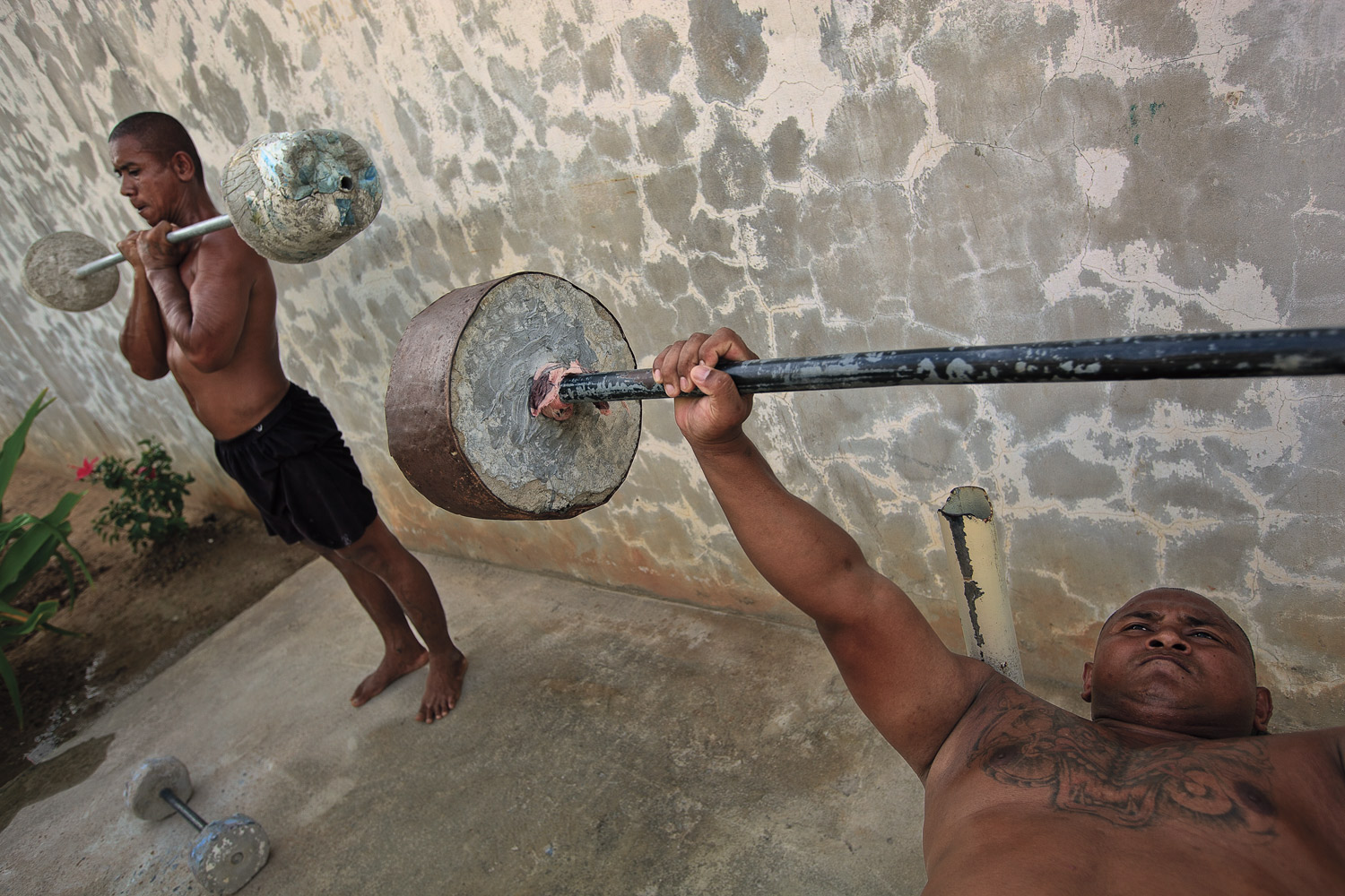 Inmates lift weights within the prison walls.