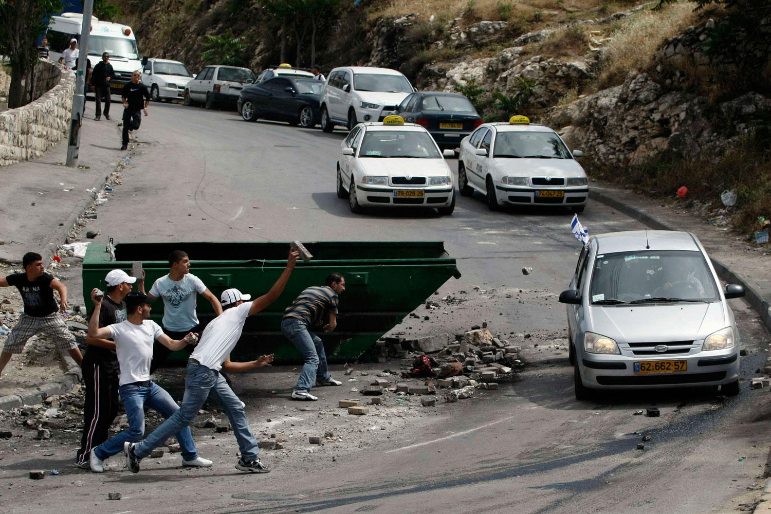 May 6, 2011.  Palestinians throw bricks and rocks at an Israeli car in the Silwan neighborhood of East Jerusalem.