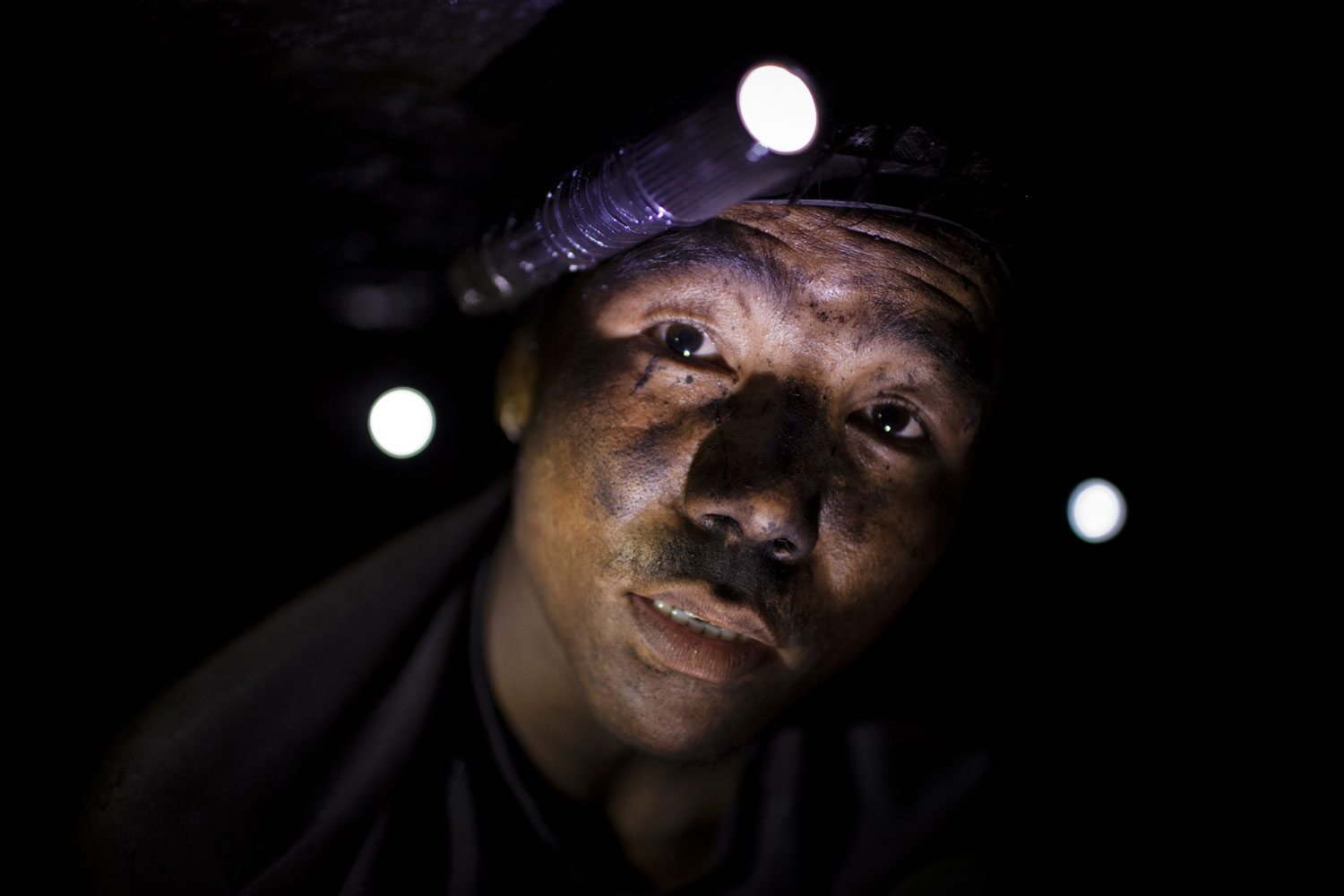22 year old Shyam Rai from Nepal pauses as he works, digging out coal, using hands and a pick to get at the seams of coal.