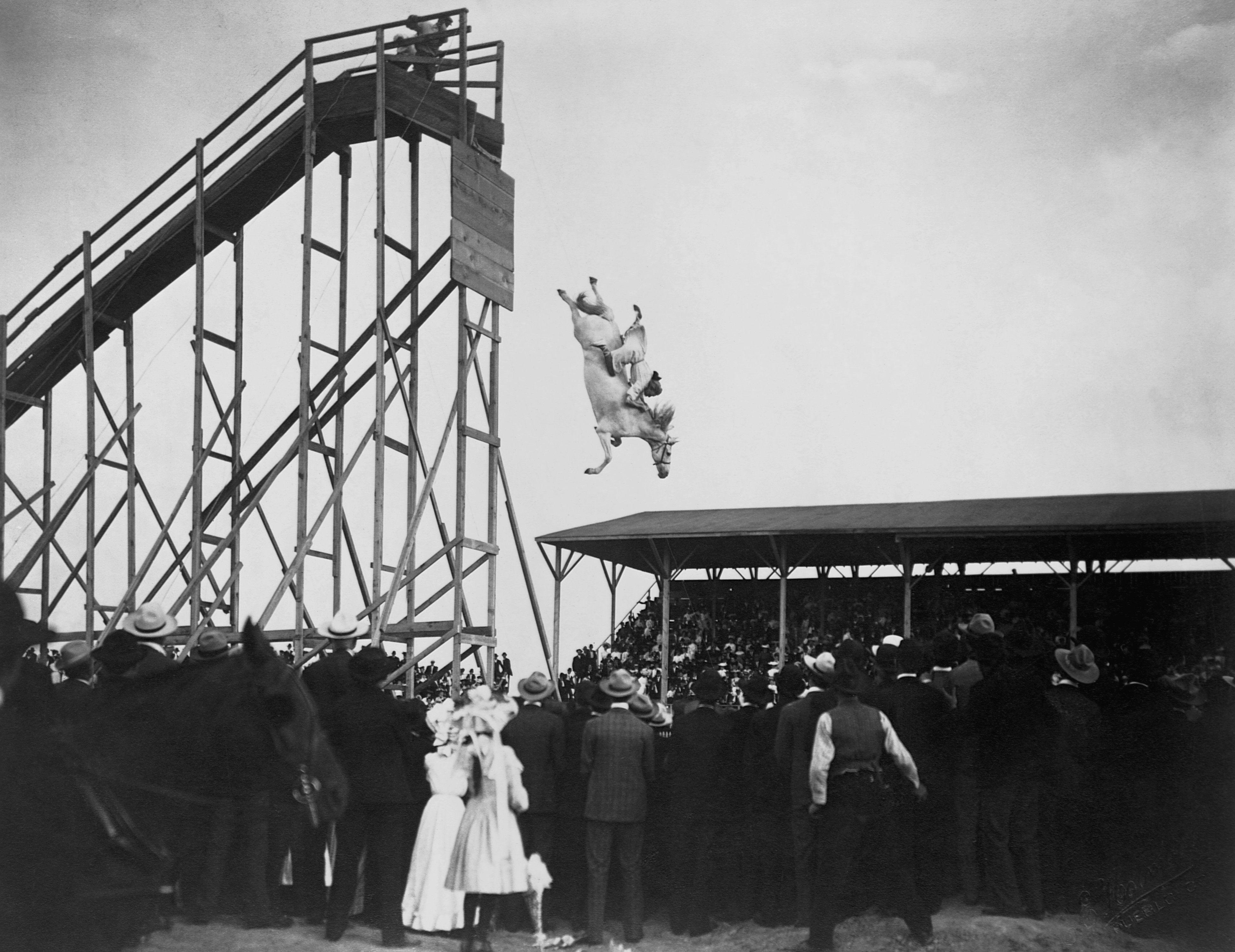 Eunice Winkless dives into a pool of water from a high tower on horseback on July 4, 1905 in Pueblo, Colorado
