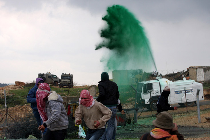 Palestinians gather for a weekly demonstration against Israel's  separation barrier in the village of Bilin, March 11, 2011.