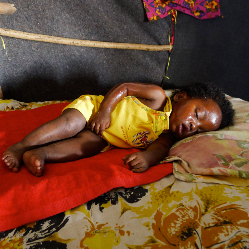 A baby sleeps after having been given a bath in St. Therese, Port-au-Prince.