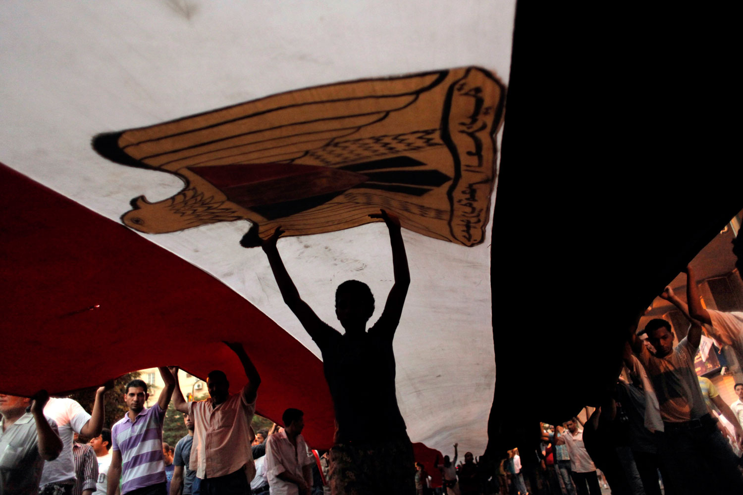 July 12, 2011. Protesters march with a giant Egyptian flag in Cairo’s Tahrir Square. Egypt’s military rulers have warned protesters against “harming public interests” as demonstrators laid siege to Cairo’s largest government building and threatened to expand their sit-in to other sites in the capital.