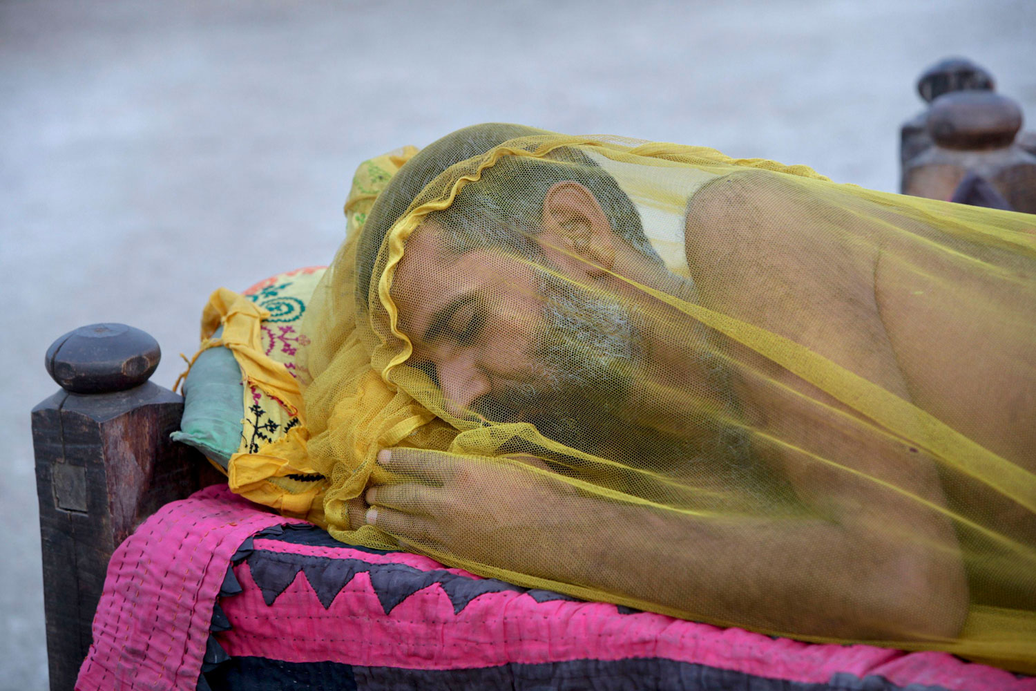 July 12, 2011. A man sleeps under an insect net in a camp for victims of floods in Sukkur, Pakistan. He has been homeless for almost a year. 5 million people are at risk of being displaced by flooding this year, following poor reconstruction after the historic 2010 disaster.