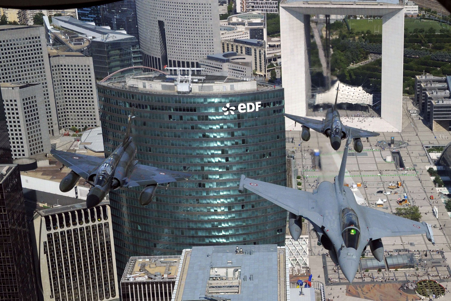 July 14, 2011. A French Rafale jet (R) flanked by two Mirage 2000-N flies over La Defense district, western Paris (background the Arch of La Defense) during the Bastille Day military parade.