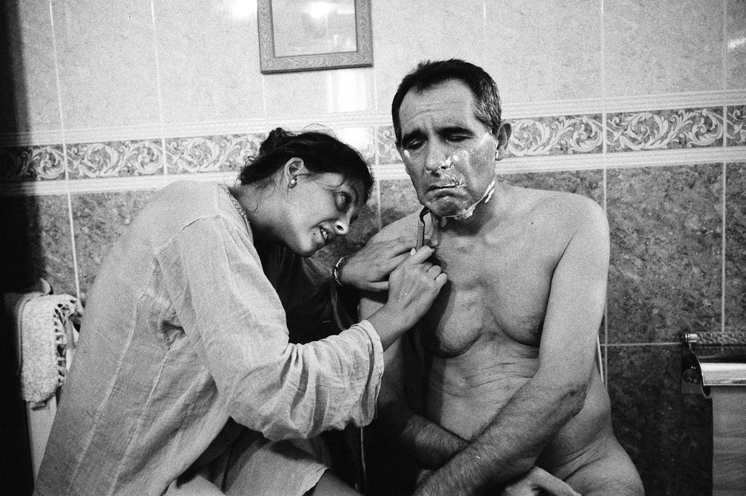 Cristina shaves her father’s face.