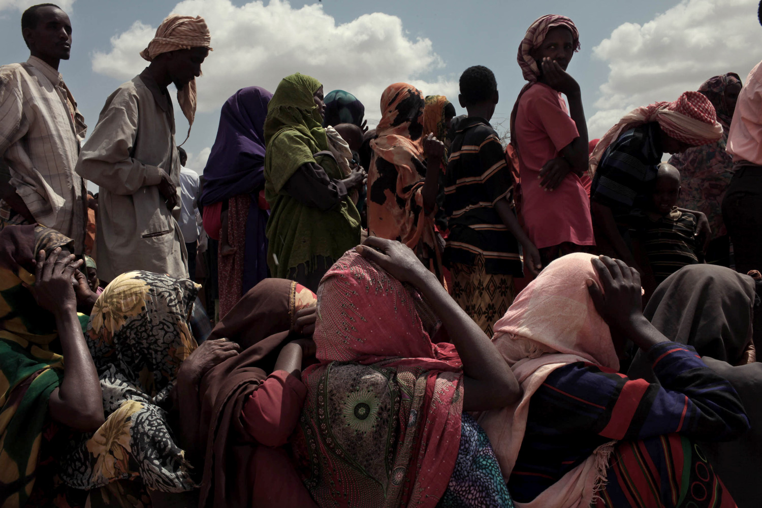 Newly arrived Somali refugees are separated by sex and then made to wait as processing begins. After having their cases processed, they are given clothes, cooking pots and food.
