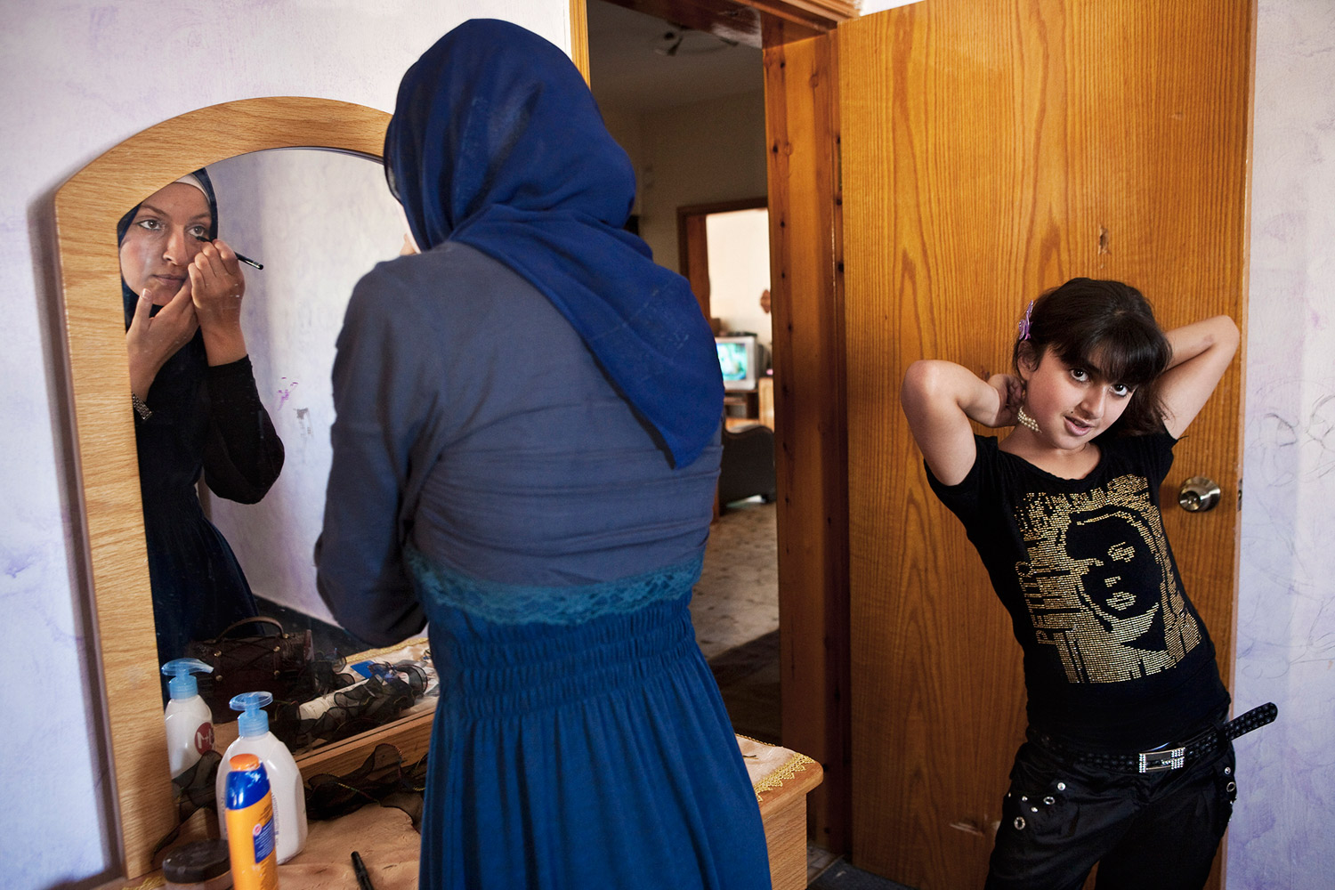 Angham Amin Essa, 18, left, puts on makeup next to her sister Johaina, 10, right, who is not yet obligated to wear a hijab (traditional Muslim head cover). Over a third of the Arab population in Israel practices a traditional Muslim lifestyle. Many young women experience discriminatory attitude from the Jewish society when wearing the hijab in public as they are required according to their religion.