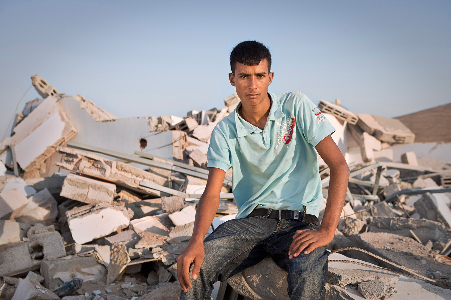 Sliman Khalil Al Dahabshe (18) sitting on the rubbles of his house in the village of Shkip. Sliman lives in one of 47 unrecognized Bedouin villages. The Israeli authorities destroyed his home defining it as an illegal structure, though his father served for many years in the Israeli army. Sliman’s family currently lives in a shed not being able to build a house fearing it would only be tore down again.