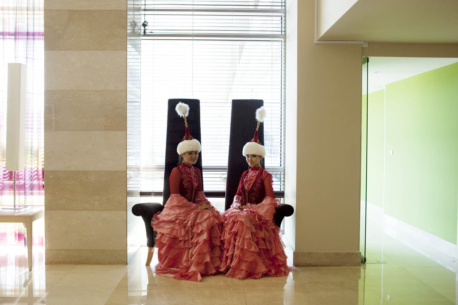 Women dressed in traditional Kazakh clothing sit waiting in the Renaissance hotel, where expat oil workers stay while visiting Atyrau on business.