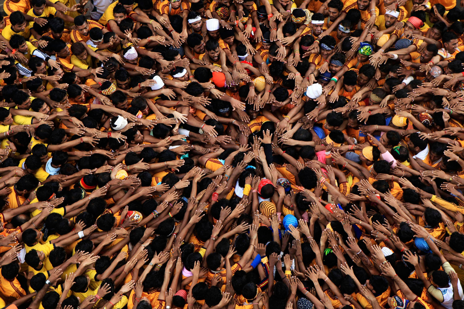 August 22, 2011. Young Indians make a human pyramid in Mumbai in an attempt to reach and break an earthen pot filled with yogurt as they celebrate Janmashtami, which commemorates the birth of the Hindu god Krishna.