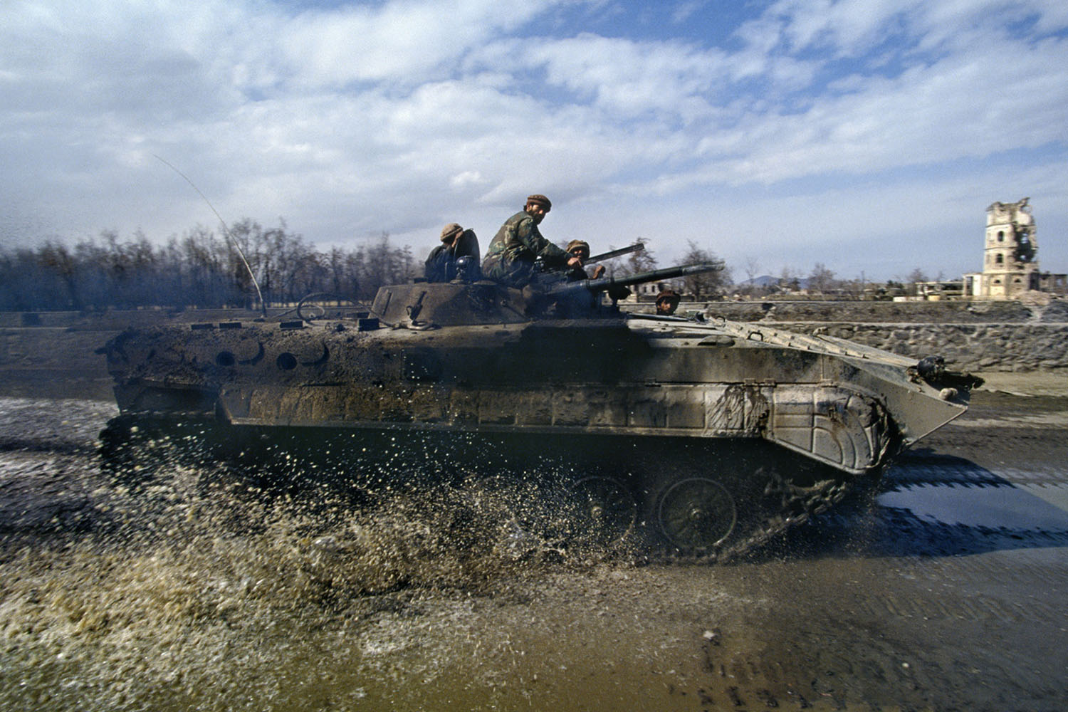 Soldiers loyal to President Burhanuddin Rabbani ride along the Kabul River in a BMP-1, a Russian-built armored vehicle. March, 1994