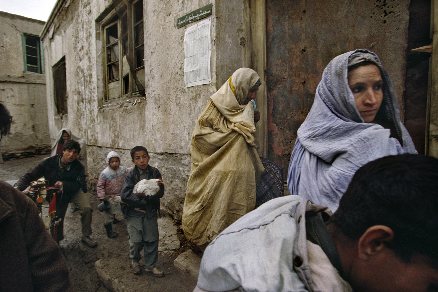 A family flees their home during factional fighting between President Rabbani government forces and the Hezb-e-Wahdat party made up of minority Hazaras. The fighting occurred near the Afshar neighborhood where a massacre of Hazara residents and militia occurred a few weeks before. March, 1993