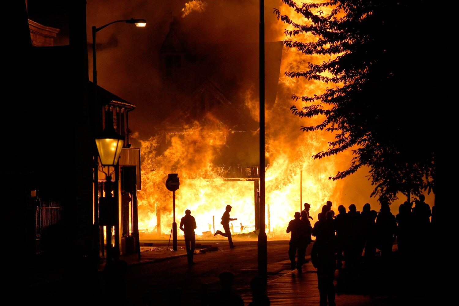 August 8, 2011. A shop is set on fire as rioters gather in Croydon, south London, violence and looting spread across some of London's most impoverished neighborhoods with youths setting fire to shops and vehicles, during a third day of rioting in the city that will host next summer's Olympic Games.