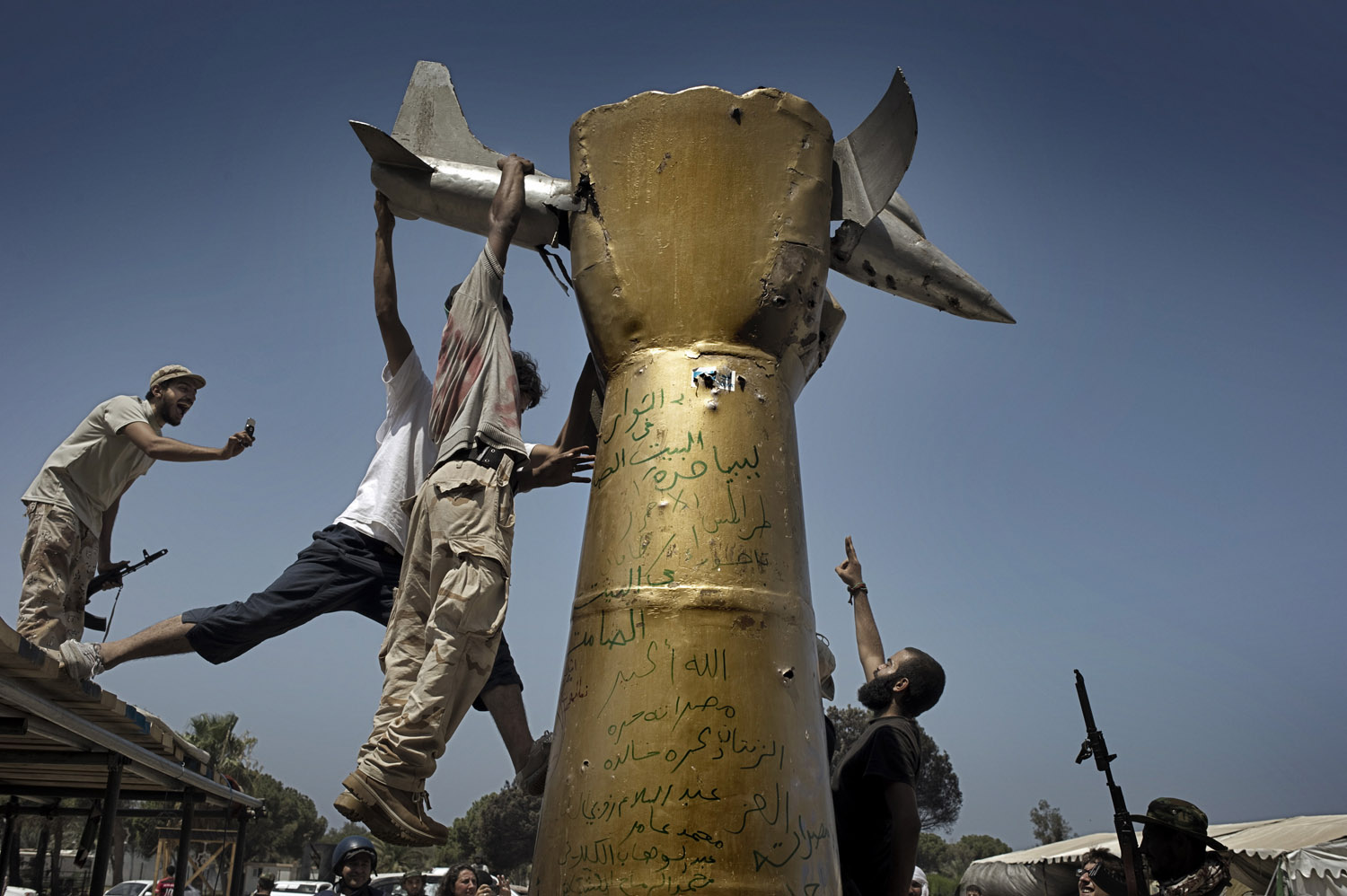 Rebels scale a statue in celebration within Gaddafi's Bab al-Aziziya compound in Tripoli, Libya, August 24, 2011.