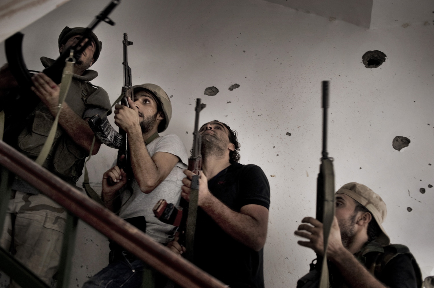 Rebel fighters clear the stairwell of a building in the Abu Slim neighborhood of Tripoli, August 25, 2011.