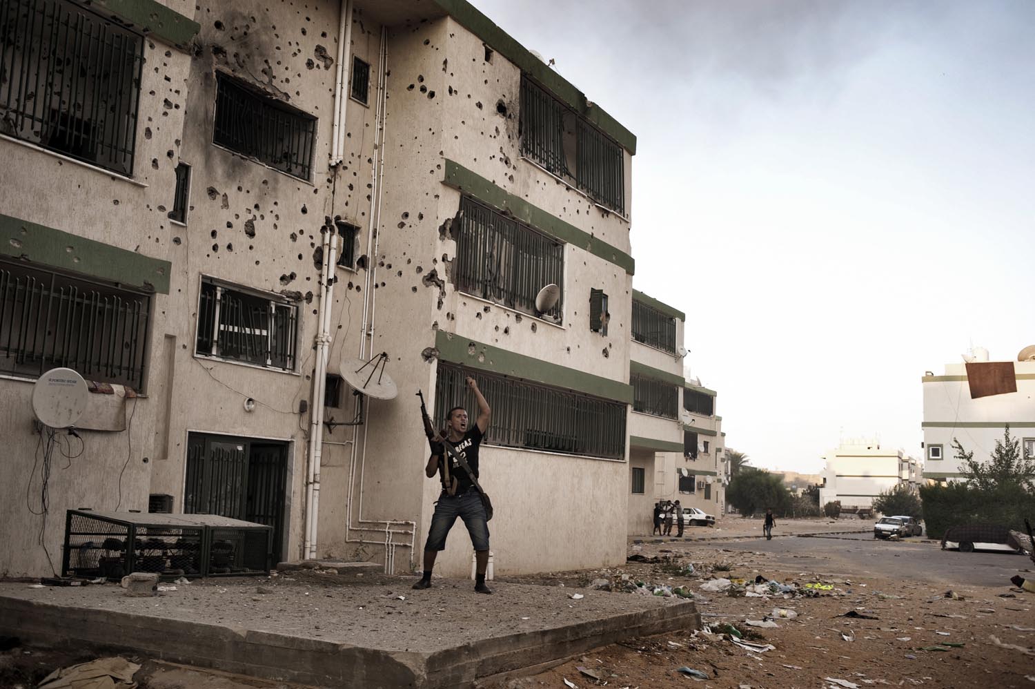 A rebel soldier motions to fellow fighters during clashes with Gaddafi loyalists in Abu Slim, August 25, 2011. Not far from Col. Muammar Gaddafi's fortified Bab al-Aziziya compound, Abu Slim has long been a Gaddafi stronghold; populated by government officials, military officers, and regime supporters.