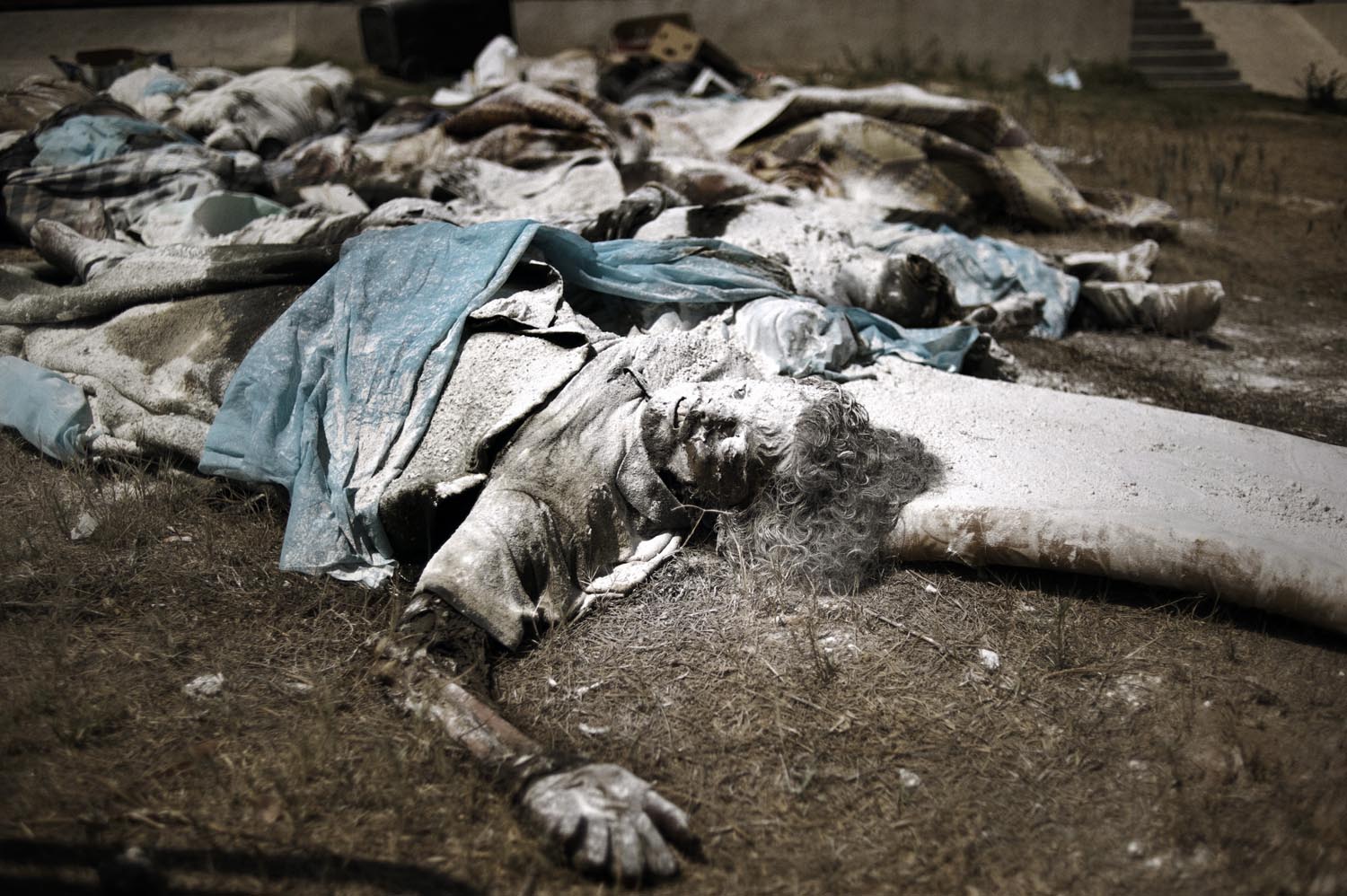 Dead bodies, some that appeared to be victims of executions, lie dumped in a yard at the abandoned Abu Slim hospital, August 27, 2011.