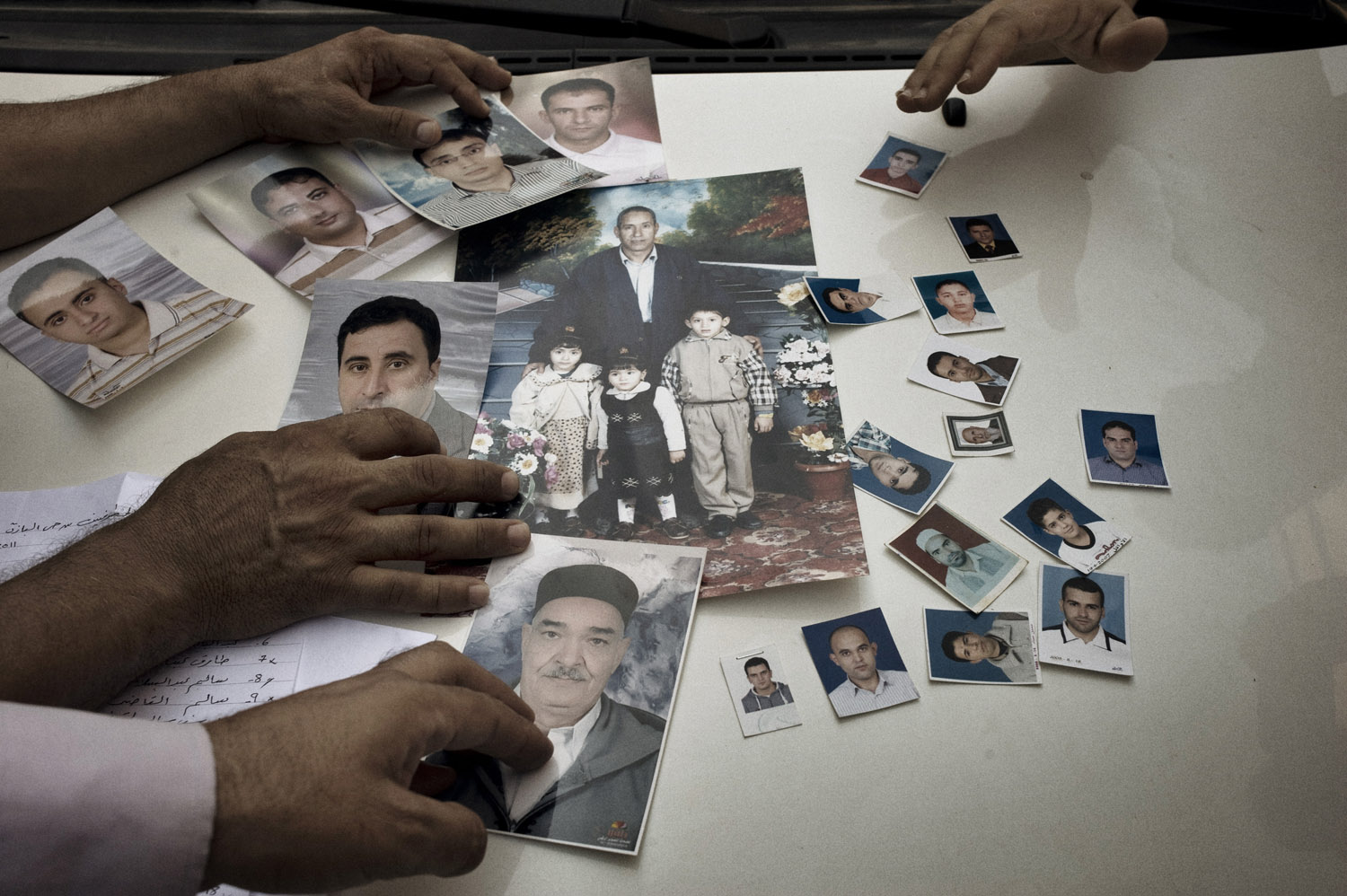 A man displays an assortment of photographs of men believed to have been killed by Gaddafi loyalists before rebels overtook Tripoli, August 27, 2011.