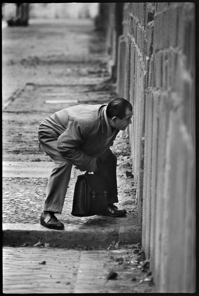 West Berliner looking into East Berlin through a crack in the Berlin Wall at the time of its construction. West Berlin, Germany, November 1961