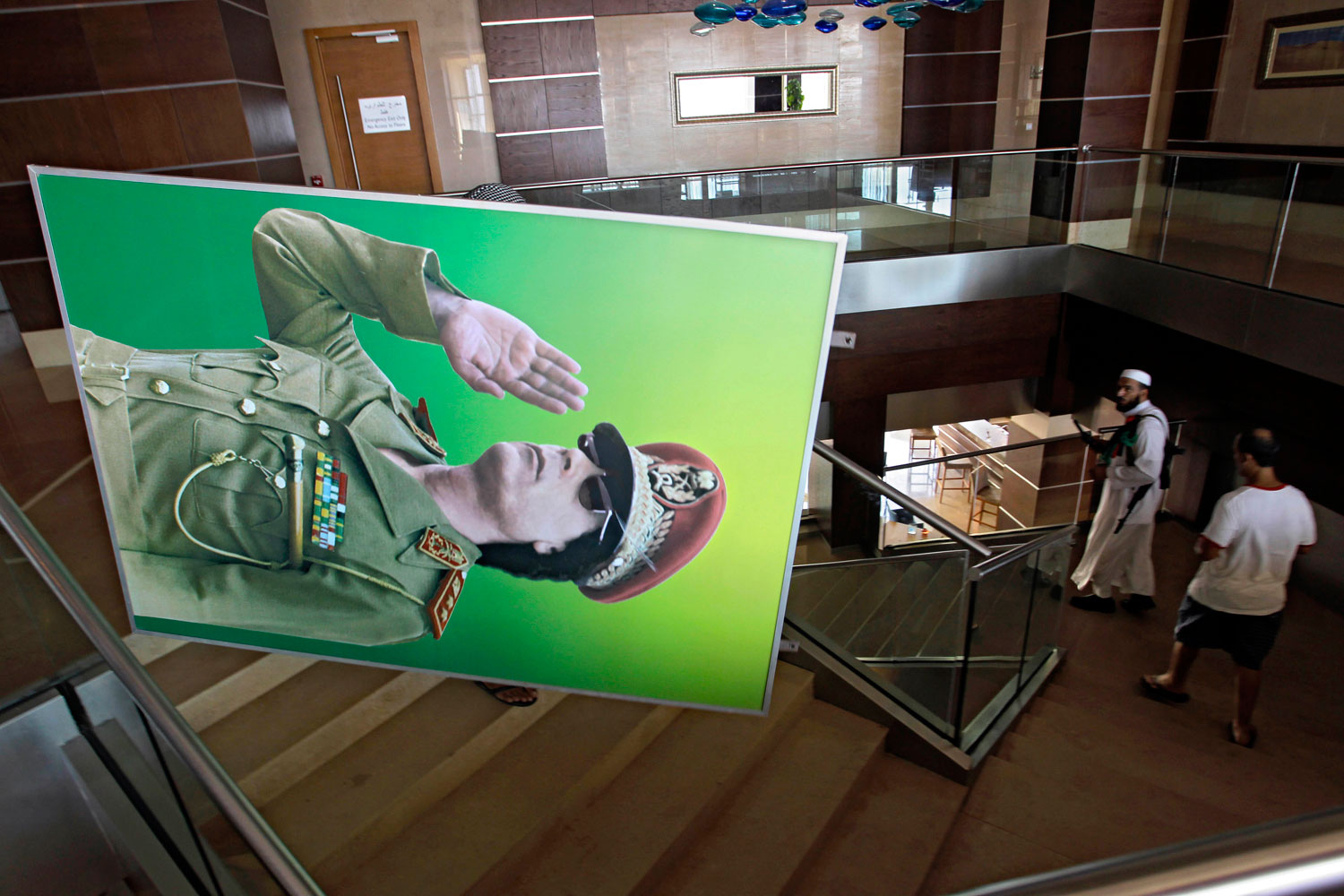 August 23, 2011. People carry a portrait of Moammar Gadhafi inside a hotel in Tripoli, Libya. Libyan rebels stormed Moammar Gadhafi's main military compound in Tripoli Tuesday after fierce fighting with forces loyal to his regime that rocked the capital as the longtime leader refused to surrender despite the stunning advances by opposition forces.