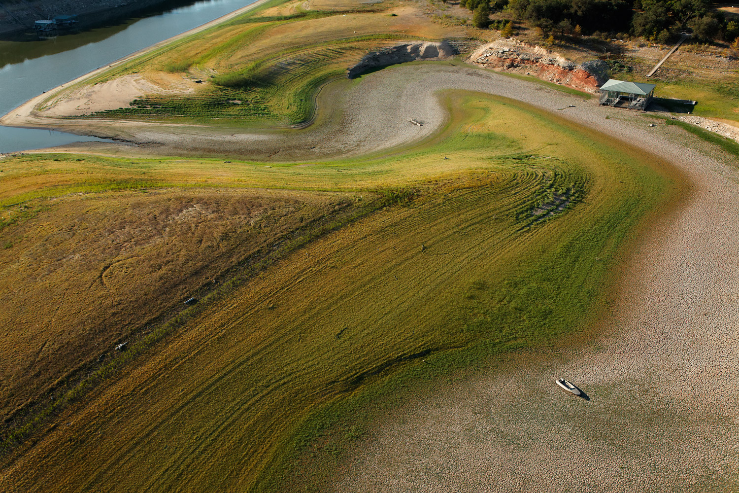 A boat sits on a dried-up creek bed that normally feeds Lake Travis, Texas.