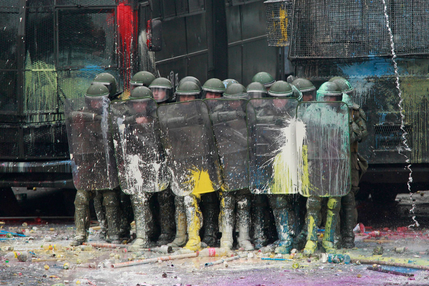 August 25, 2011. Police are pelted with paint thrown by demonstrators near the presidential palace in Santiago, Chile. A two-day strike that began as a student protest for free education mushroomed into a larger movement for reforms to labor laws and pensions and increases in corporate taxes to fund health and education.