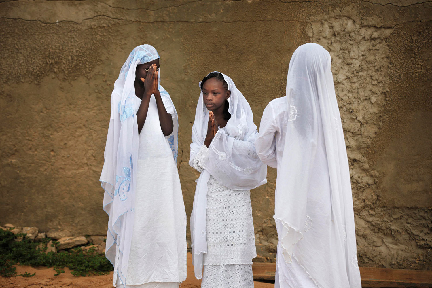 August 31, 2011. Girls pray next to a cemetery after Eid al-Fitr prayers marking the end of the Muslim holy month of Ramadan in Dakar, Senegal.