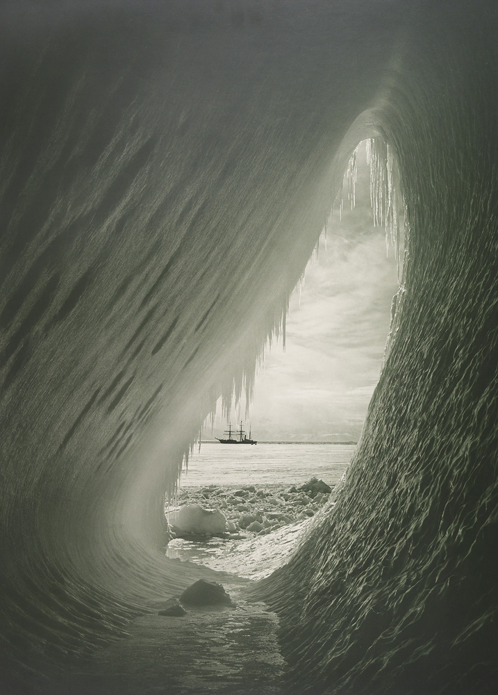An ice grotto, framing the Terra Nova. Ponting was struck by the colors of the ice inside the grotto, which were a mix of blues, purples and greens on January 5, 1911.