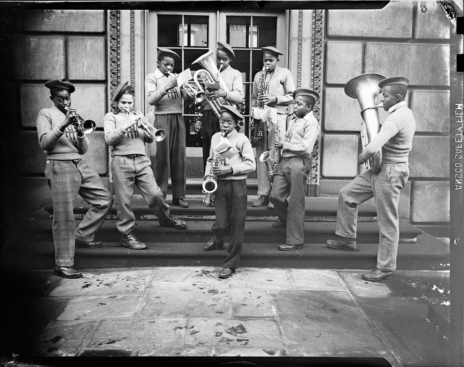 A group of boys, possibly from Herron Hill School, playing brass instruments on steps, 1938-1945.