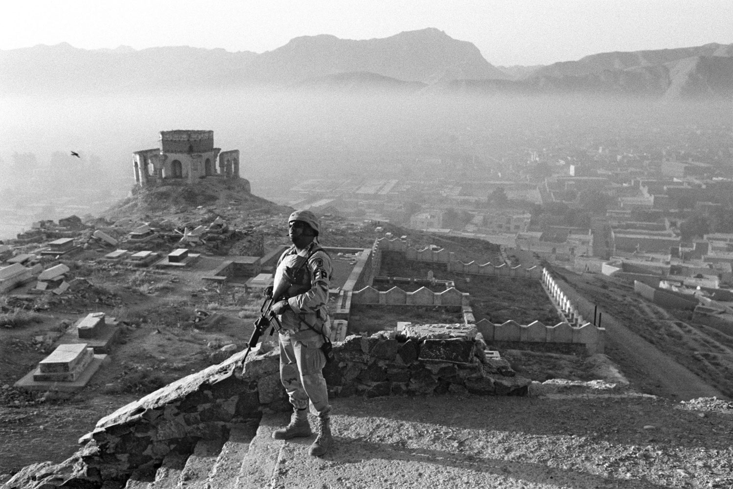 Abbas, September 2005
                               A GI on patrol in Kabul seems lost among the ruins overlooking the capital, shrouded in the mist of dawn. Are these ruins historical or the result of recent battles? What  is an armed African-American soldier doing in a Central Asian city? What invisible enemy is he guarding against?   The photo is a symbol of America’s presence in Afghanistan. It reminds me of the film The Desert of the Tartars.