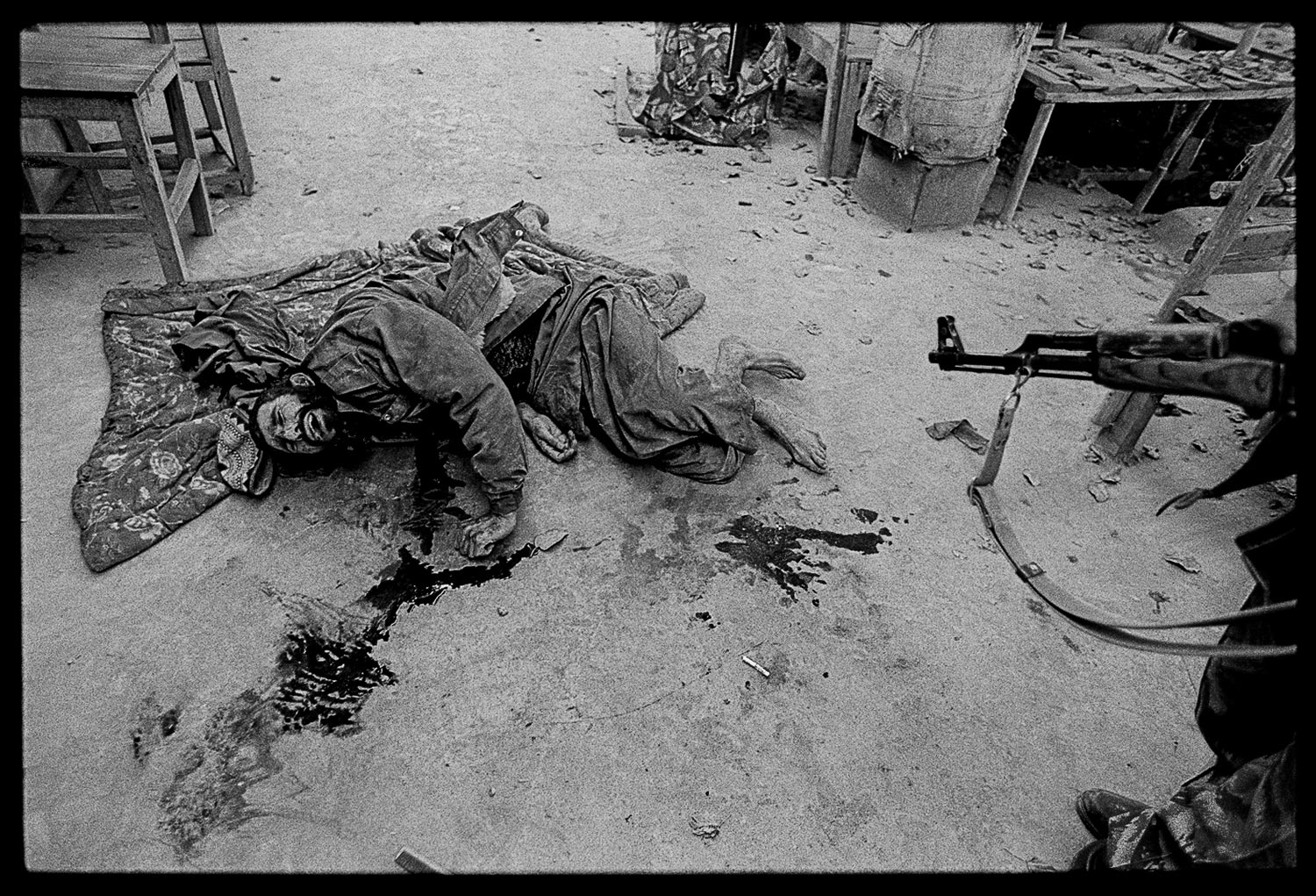 James Nachtwey, November 22, 2001
                               The carefully negotiated hand-over of the city of Kunduz might be as good a reference as any to comprehend the reality of peace agreements in Afghanistan. Located in the north, near Uzbekistan, Kunduz was the last major stronghold of the Taliban following its withdrawal from Kabul. It had been under siege by the Northern Alliance, and an agreement was forged in which Taliban fighters would surrender in exchange for safe passage, and the city would be occupied by the alliance.
                              
                              For a couple of days, the Taliban began to drive out to their enemy’s lines and relinquish their weapons. On the appointed day, a large convoy of Northern Alliance troops moved forward. As it entered the city center, the remaining Taliban fighters opened fire from every direction. Chaos ensued. Both incoming and outgoing fire, from assault rifles, machine guns and rocket propelled grenade launchers was so dense and haphazard, one was as dangerous as the other, no matter which side you happened to be on. It was impossible to figure out where to take cover. Survival would be a matter of luck, and every moment carried the expectation of being hit.
                              
                              When the shooting was finished, the dead and dying were scattered about the streets. This Taliban fighter had been shot in the stomach and was slowly and painfully slipping away. The peaceful hand-over was later trumped by the guarantee of safe passage, in which dozens of Taliban who had turned themselves in were suffocated to death in the shipping container that was supposedly being used to transport them to a secure location.