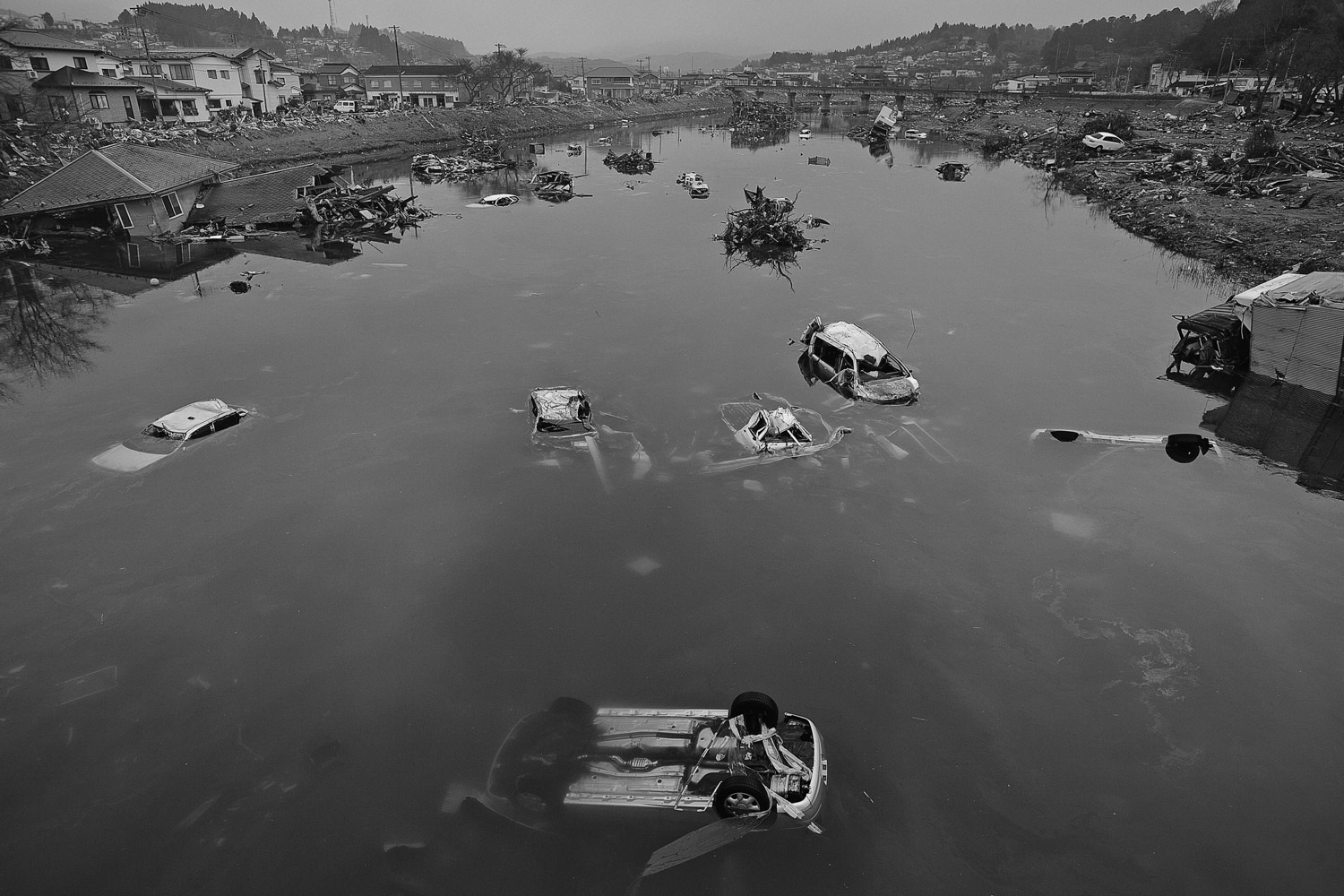 James Nachtwey. From  The Day the Earth Moved.  March 28, 2011 issue.
                              Cars totaled by the tsunami are strewn across a river that runs through Kesennuma, Japan on March 15, 2011.