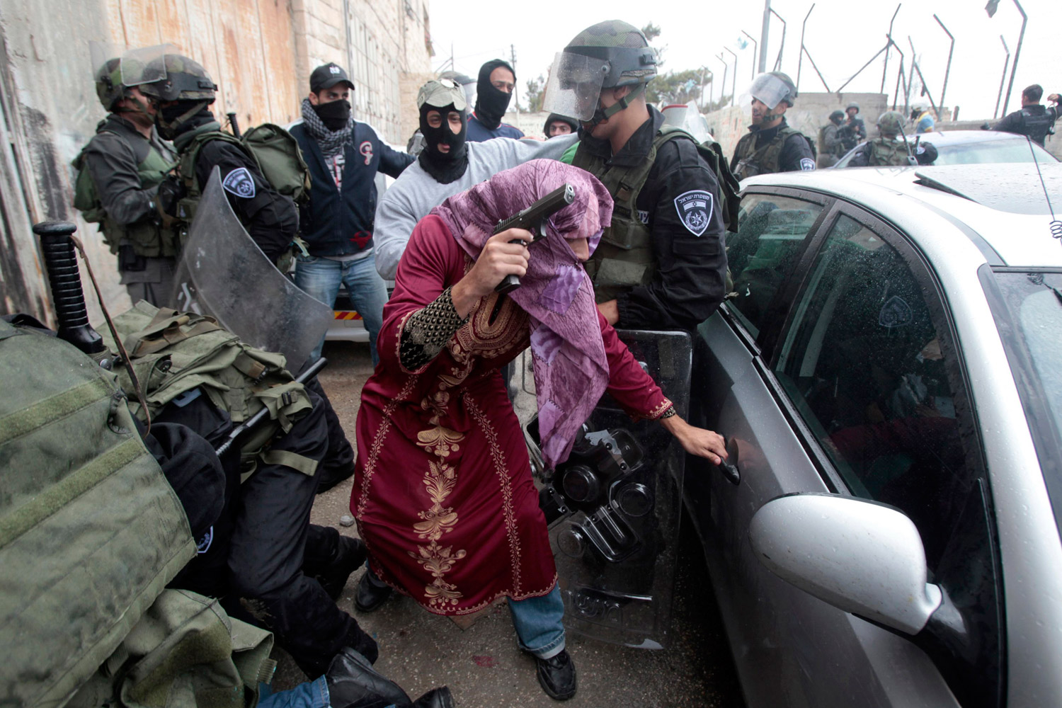 May 15, 2011. An undercover Israeli policeman dressed as a Palestinian woman opens a car door after detaining a Palestinian protester during clashes in Shuafat refugee camp, in the West Bank near Jerusalem. Israeli security forces had been on alert for violence on Sunday, the day Palestinians mourn the  Nakba,  or catastrophe, of Israel's founding in a 1948 war, when hundreds of thousands of their brethren fled or were forced to leave their homes.