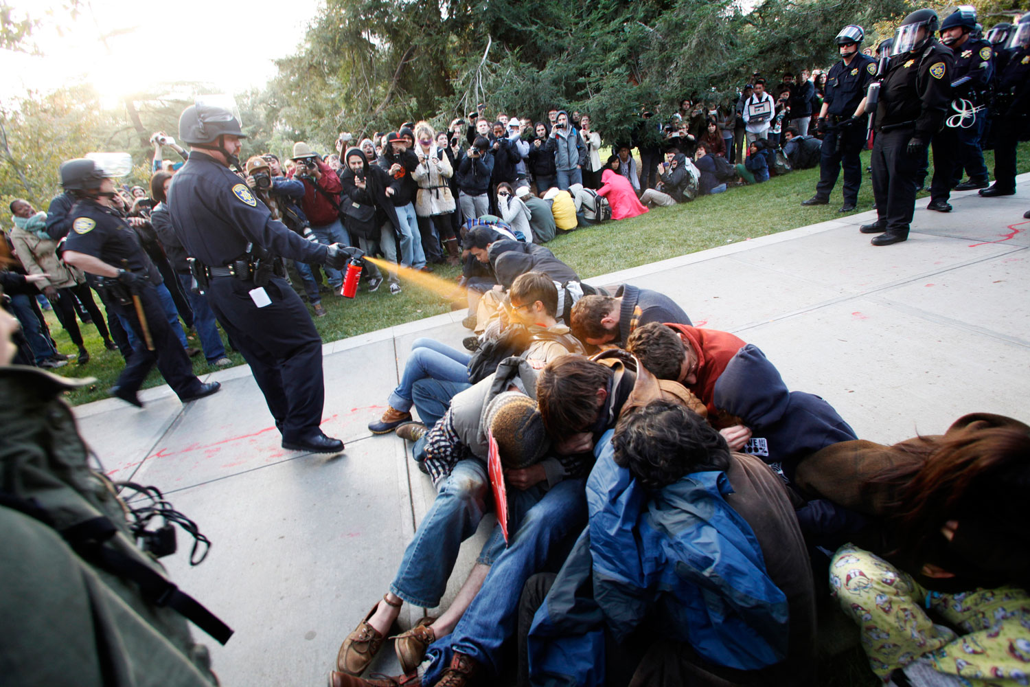 November 18, 2011. University of California, Davis Police Lt. John Pike uses pepper spray to move Occupy UC Davis protesters while blocking their exit from the school's quad Friday in Davis, Calif. Two University of California, Davis police officers involved in pepper spraying seated protesters were placed on administrative leave November 20, 2011, as the chancellor of the school accelerates the investigation into the incident.