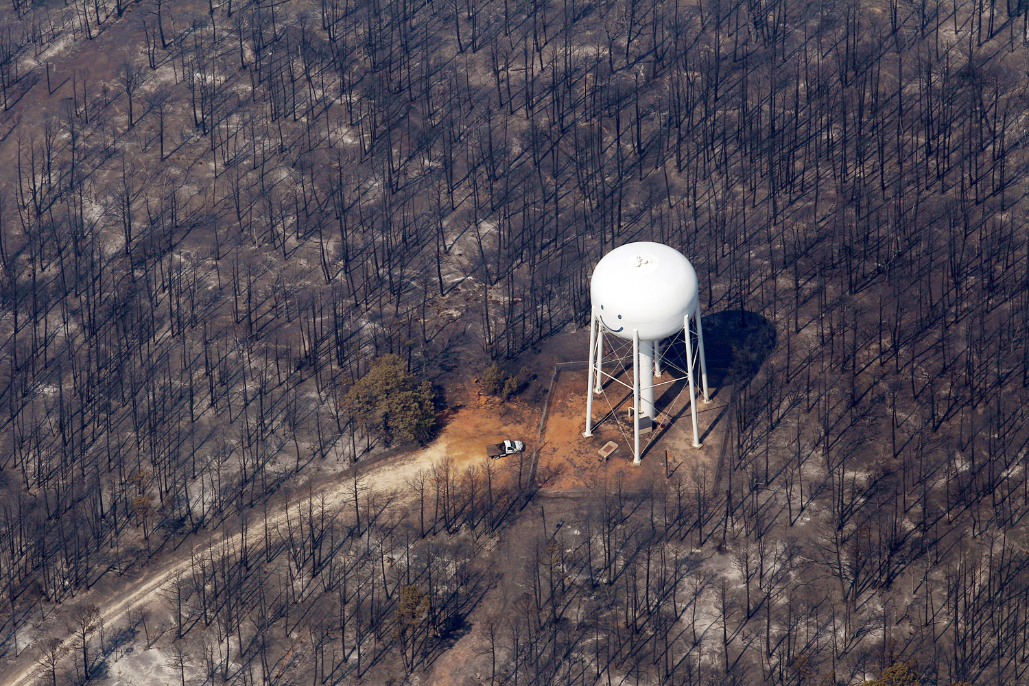 September 7, 2011. An area destroyed by wildfire surrounds a water tower in Bastrop, Texas. The fire has destroyed more than 600 homes and blackened about 45 square miles in and around Bastrop.
