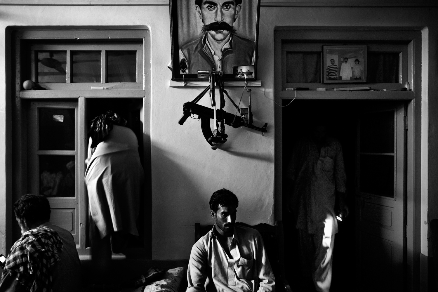Pakistan, Swat Valley, Bara Bandai, November 2010. Lashkar members making preparations for pehra (night patrol) at the hujra of tribal elder Ahmed Khan, whose portrait is on the wall. In Pashtun culture a hujra is a place where tribal elders assemble to discuss different issues, sometimes holding meetings, called jirga, to settle any sort of dispute or evolve future strategies.