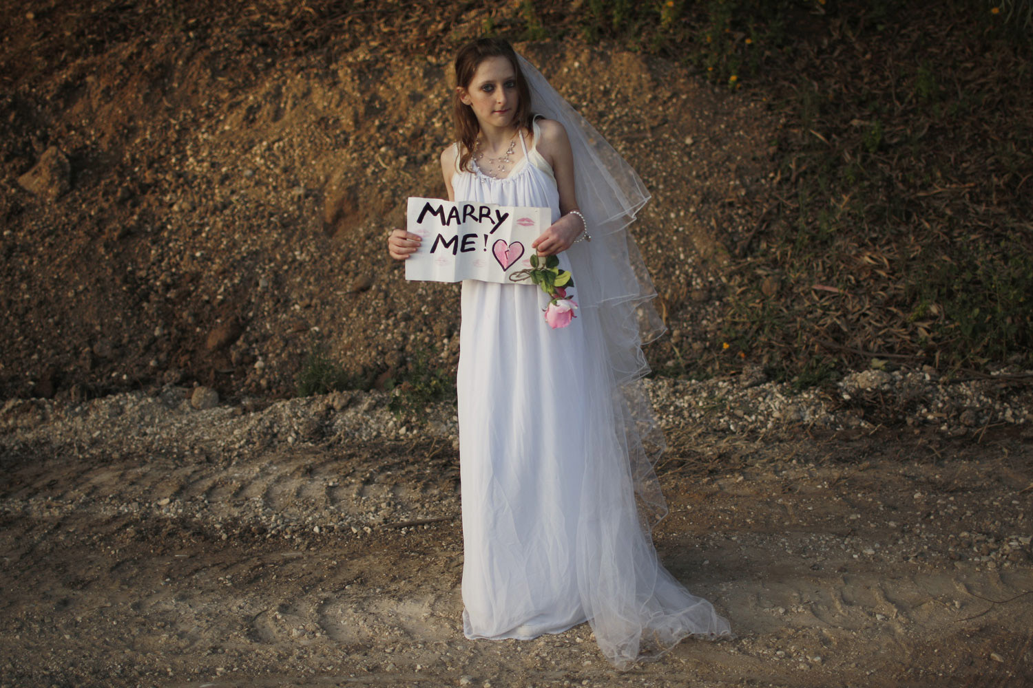 Hallel Goldamna, 13, wears a wedding dress as she holds a sign for Canadian singer Justin Bieber ahead of his concert in Tel Aviv. April 14, 2011