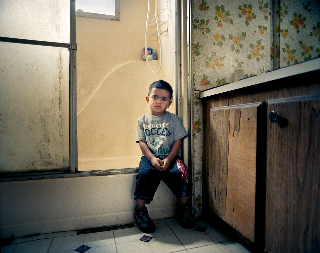 Joakim Eskildsen. From  Below The Line: Portraits of American Poverty.  Published on LightBox, November 17, 2011.
                              
                              Eric, 3, lives with two siblings, his mother and grandparents in a trailer park for migrant farm workers in Firebaugh, Calif. His grandmother regularly walks two miles with him to pick up free food from the local community center to supplement the family’s $350/week income. June 1, 2011.