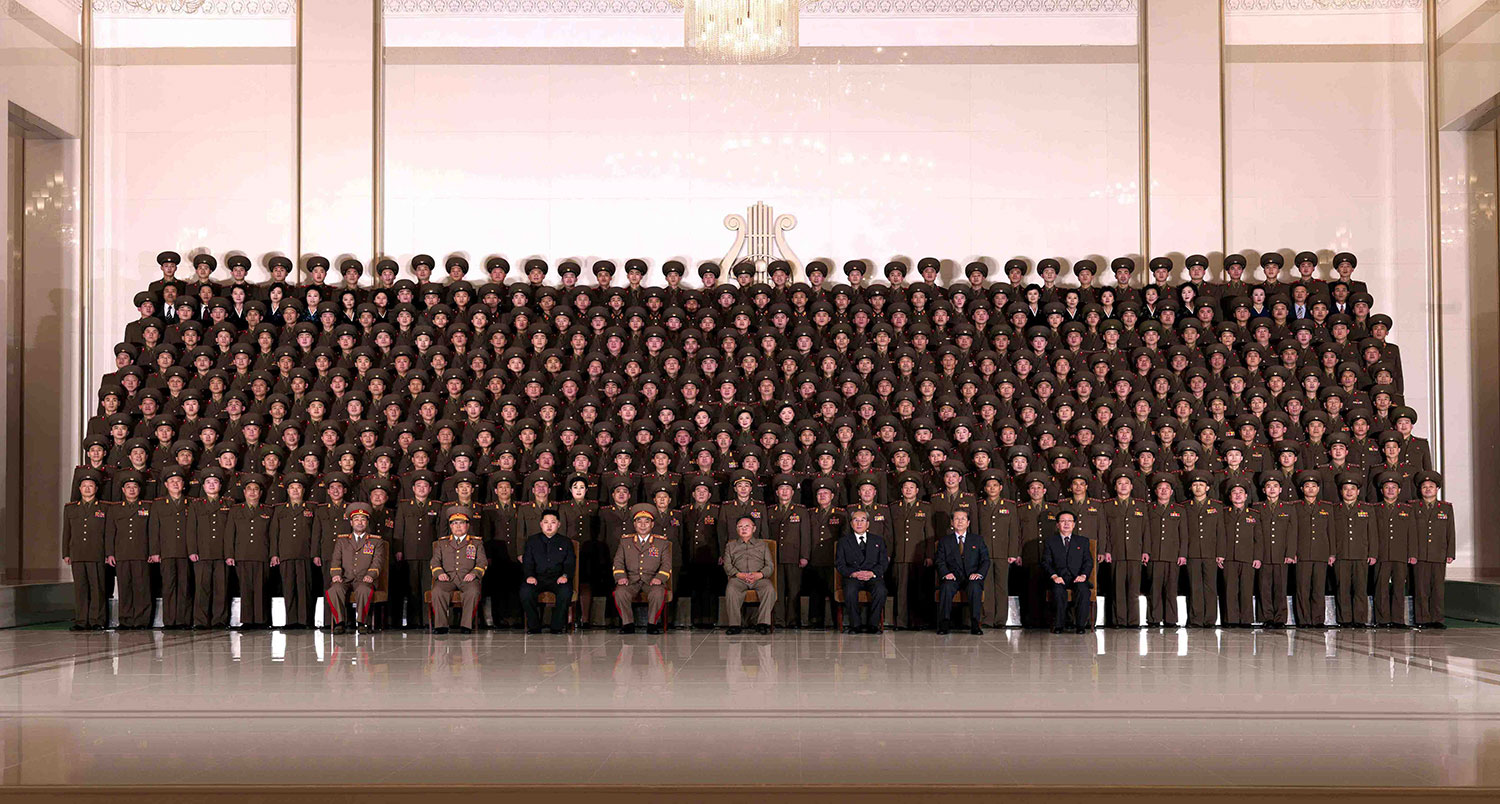 This photo, released by KCNA on Dec. 26, 2010, shows Kim Jong Il (front row, fourth from right), and Kim Jong Un (front row, third from left), posing for a photo with members of the State Merited Chorus after the  Concert Celebrating December Holiday  in Pyongyang.