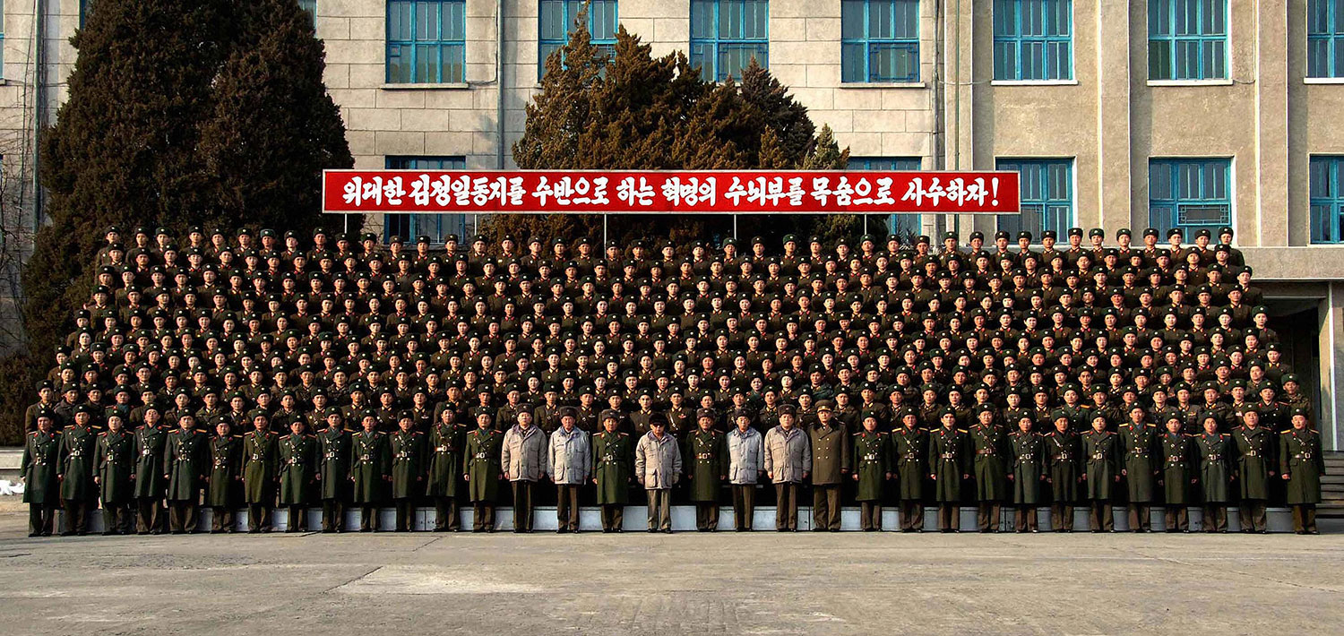 This undated picture, released by KCNA on Feb. 7, 2009, shows Kim Jong Il (center, in sunglasses) posing with servicemen of the Large Combined Unit 324 during an inspection.